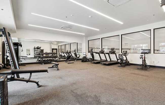 A spacious gym with a variety of equipment including treadmills, exercise bikes, and weight machines.