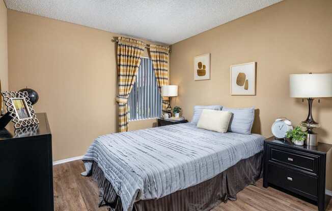 A bedroom with a bed, nightstand, and lamp.