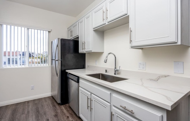 a kitchen with white cabinets and stainless steel appliances