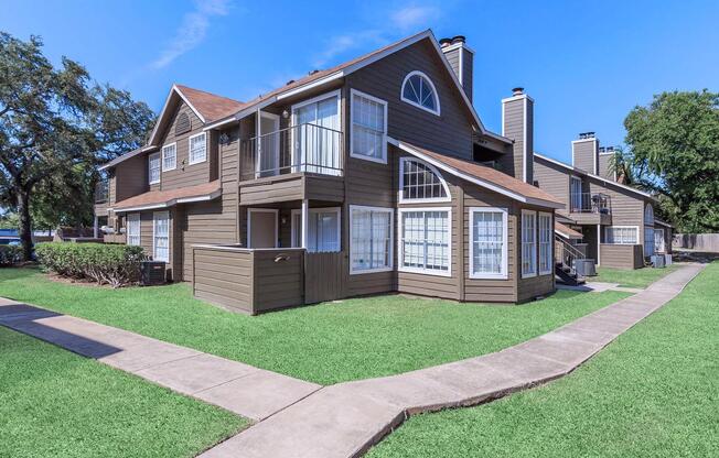 a house with a lawn in front of a brick building