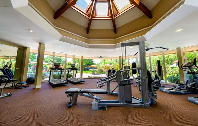 A gym with a variety of equipment and a skylight.