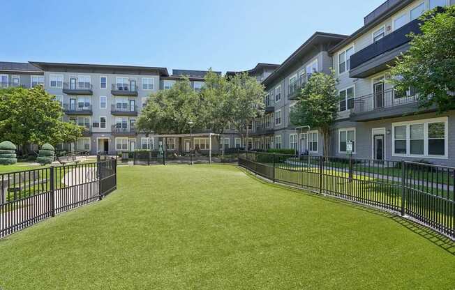 A grassy area in front of apartment buildings.