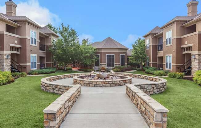 A stone courtyard with a fountain in the center of residential buildings.