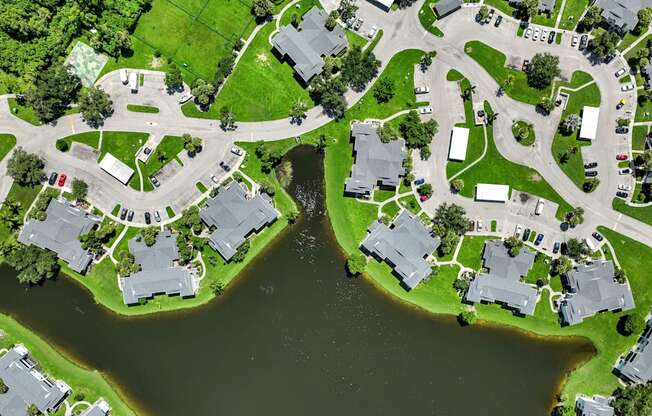 an aerial view of houses next to a body of water