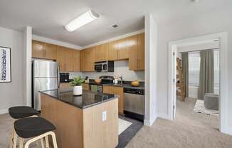 A kitchen with a refrigerator, microwave, oven, and sink.