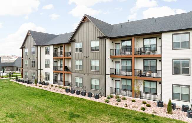 an exterior view of an apartment building with a green lawn