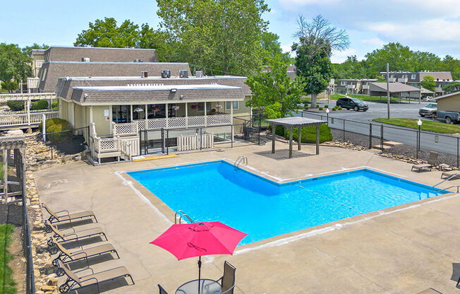 a swimming pool with an umbrella in front of a house