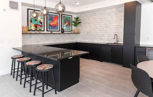 a kitchen with a black island and bar stools