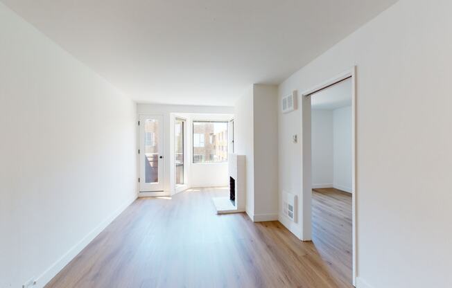 a bedroom with hardwood floors and white walls