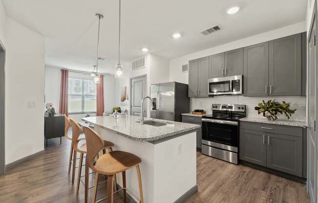 A modern kitchen with wooden chairs and stainless steel appliances.