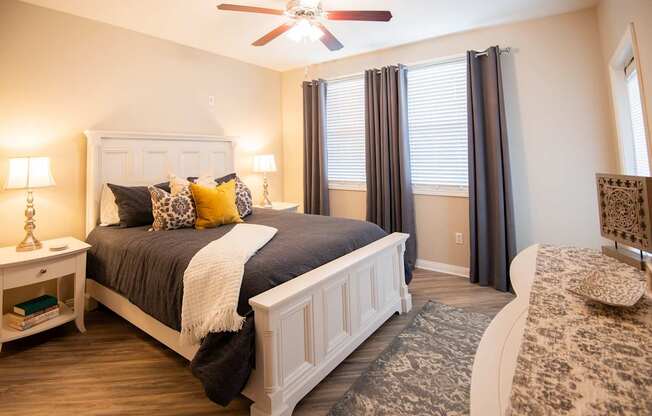 A bedroom with a large bed and a ceiling fan.