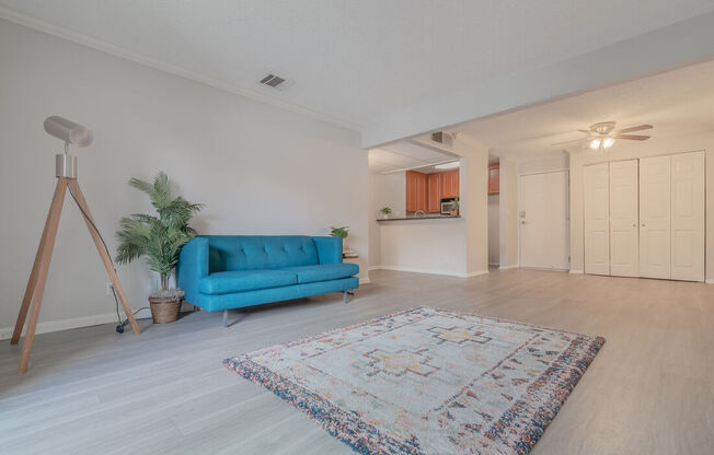 a living room with a blue couch and a carpet at City View Apartments at Warner Center, Woodland Hills California