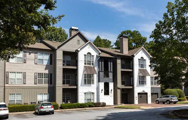 A large apartment complex with multiple buildings and cars parked in front.