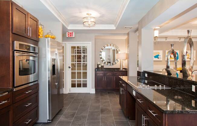 Resident Kitchen with Granite Countertops, Dark Wood Cabinets and Stainless Steel Appliances at Canton Woods apartments in MA