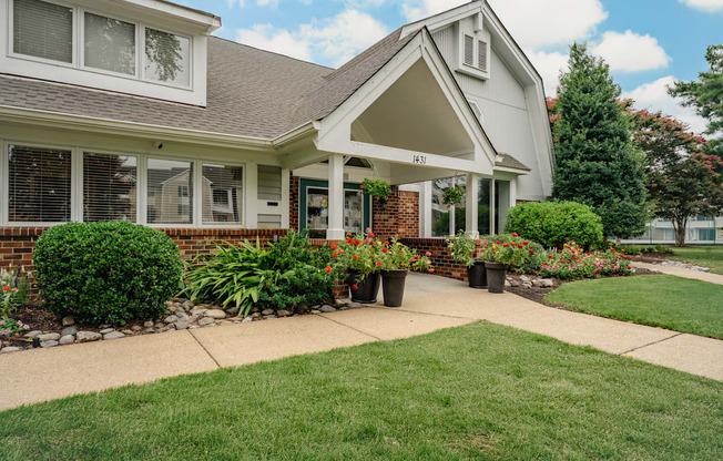 A house with a white front porch and a green lawn.