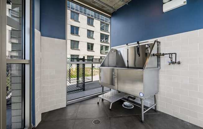 a large stainless steel tub sits in the corner of a room with a balcony in the background at Lakeview 3200 Apartments, Illinois, 60657