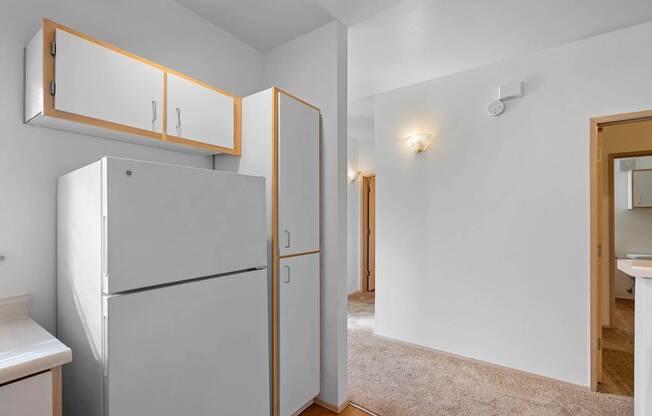 a renovated kitchen with white cabinets and a refrigerator