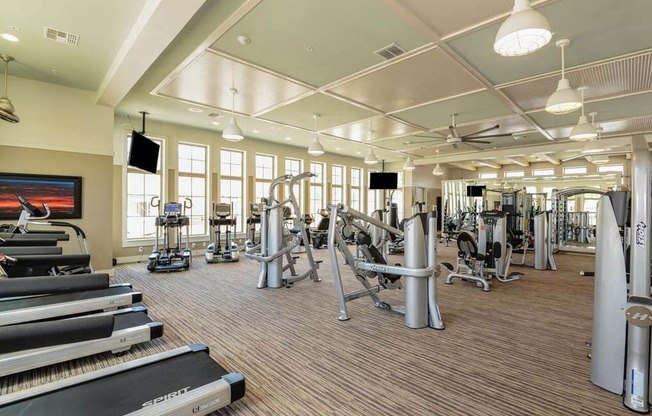 a spacious fitness center with cardio equipment and a flat screen tv  at Palm Bay Club, Jacksonville, Florida