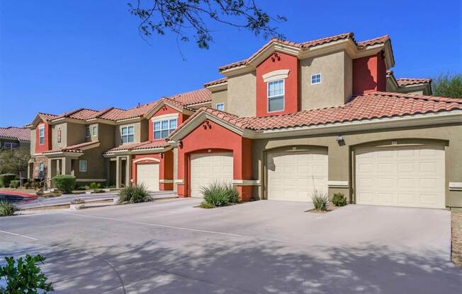 A row of houses with red roofs and garages.