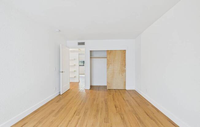 A room with a wooden floor and a white wall.