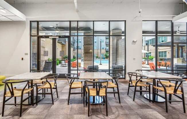 a dining area with tables and chairs and glass doors at Link Apartments Innovation Quarter, North Carolina, 27101