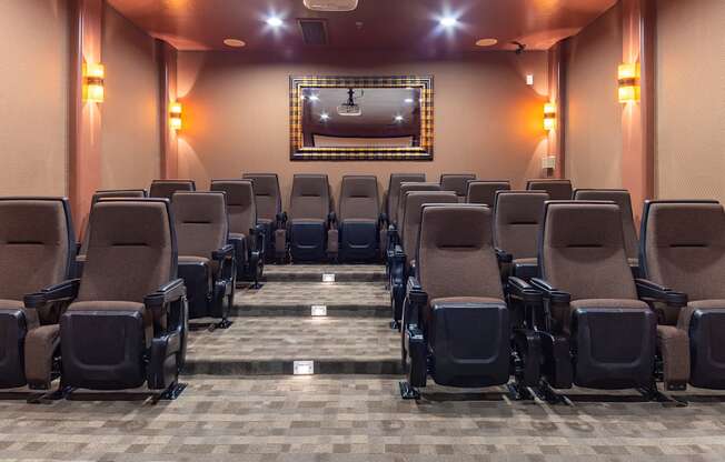 a large auditorium with chairs and a projector screen