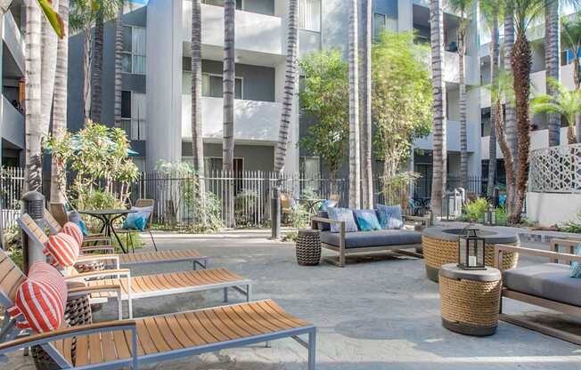 A modern building with a courtyard surrounded by palm trees.