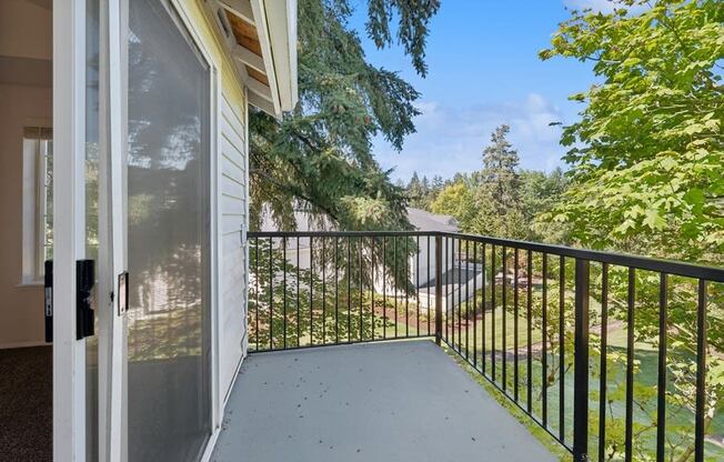 the balcony has a view of the yard and the street