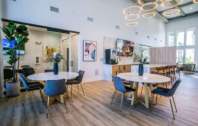 A modern dining room with a white table and blue chairs.