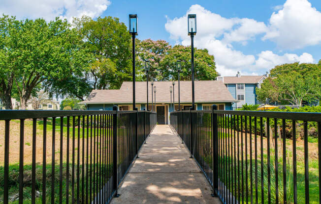 a walkway leading to a building with a fence