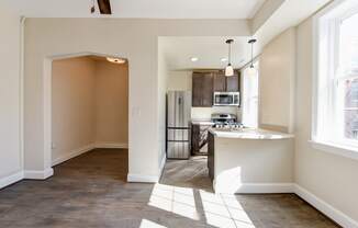 kitchen with espresso cabinetry, breakfast bar and stainless steel appliances at petworth station apartments in washington dc