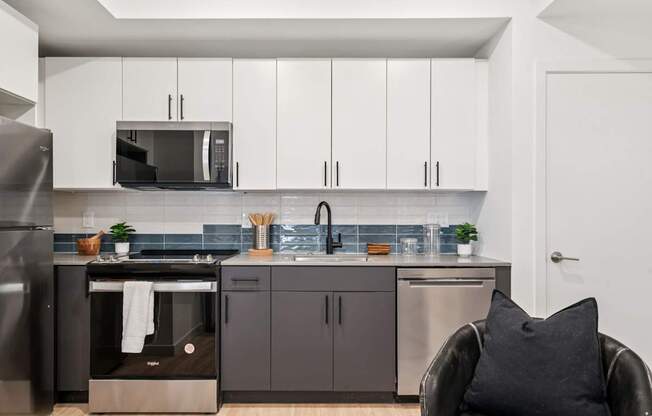 A modern kitchen with a black chair and a black pillow.