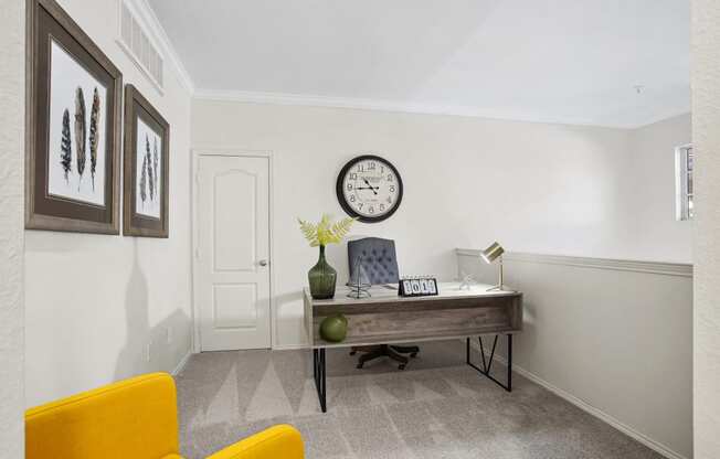 a home office with a desk and a clock on the wall