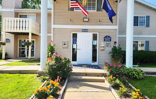 The front of a building with a white door and a sign that says