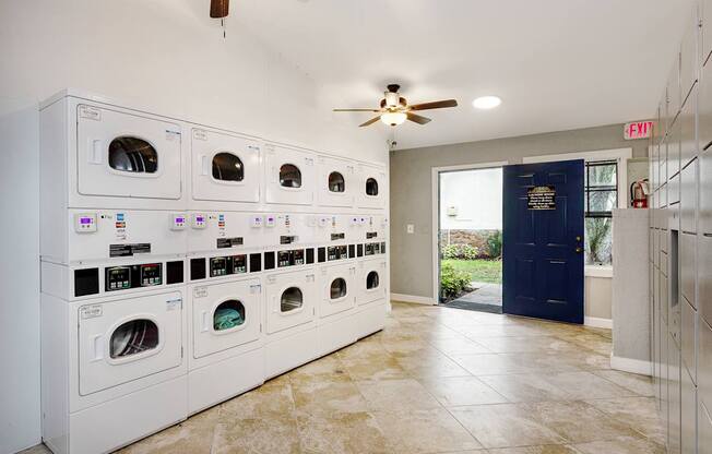 A laundry room with a row of washers and dryers.
