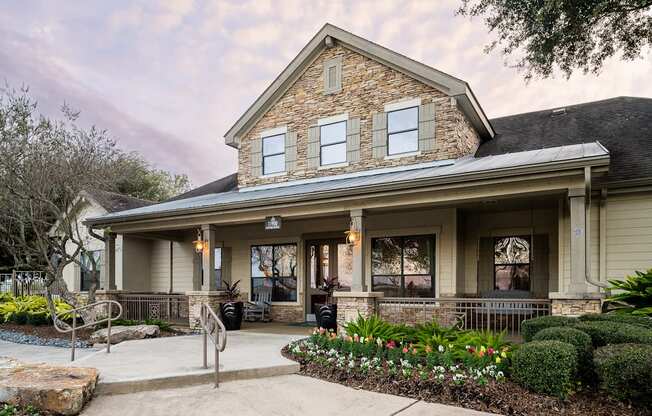 A house with a front porch and a stone wall.