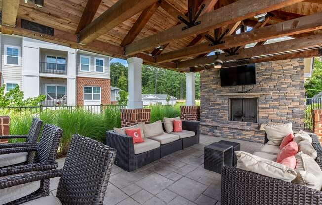 covered outdoor lounge area with fireplace and TV