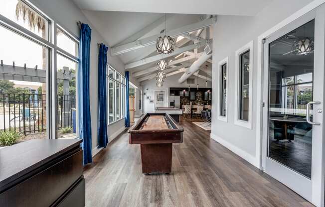 a pool table in the center of a room with glass doors