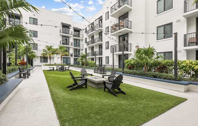 a courtyard with a table and chairs in front of some apartments