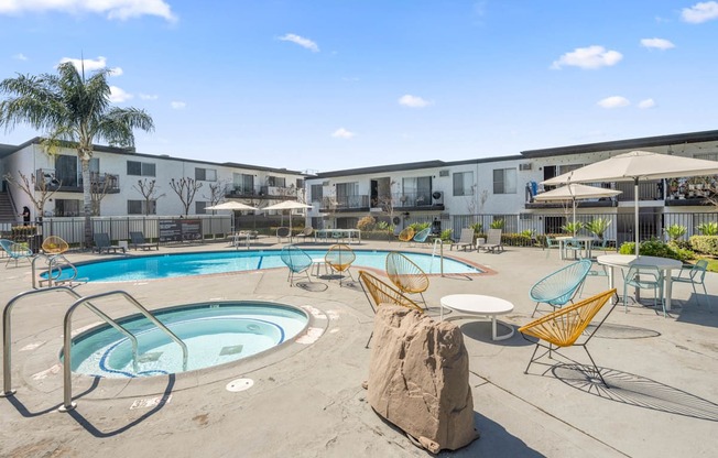 A large outdoor swimming pool with a rock in the middle of it.