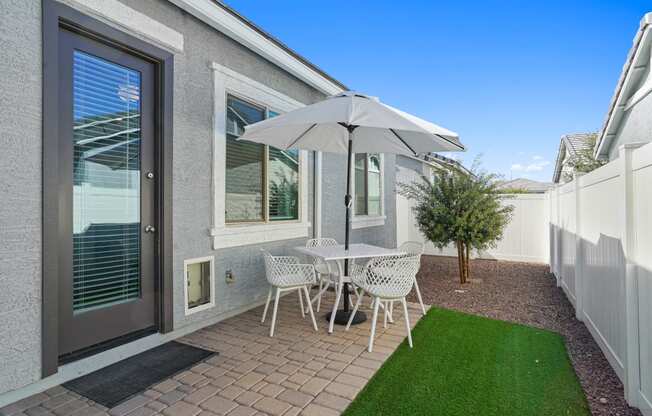patio with stone and turf and table with chairs and umbrella