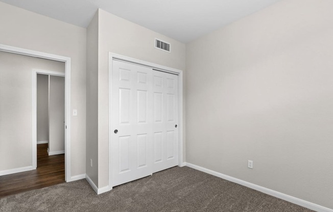 a bedroom with a white door and a door to a closet at Switchback on Platte Apartments, Littleton, 80120