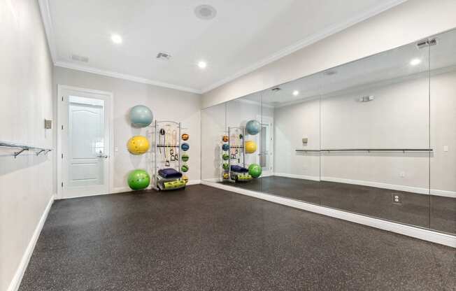the living room has a workout room with weights and mirrors
