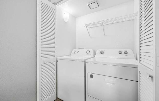A white laundry room with a washer and dryer.