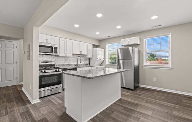 a kitchen with a large island and stainless steel appliances