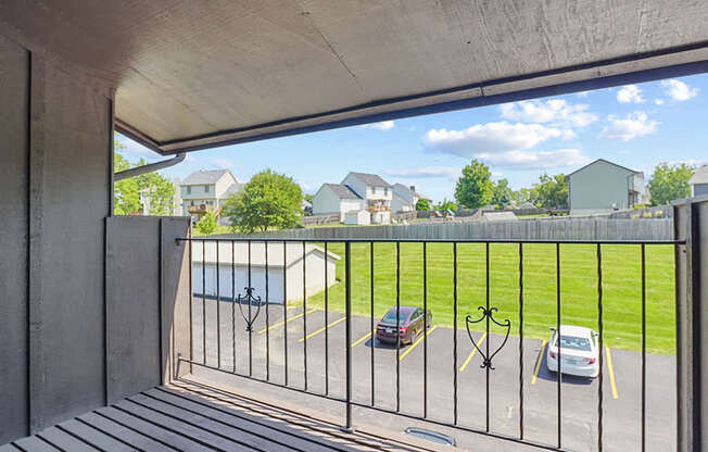 A view from a balcony looking out at a parking lot.