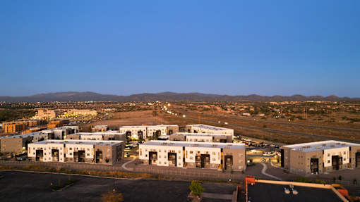 A large industrial complex with multiple buildings and a winding road in front.