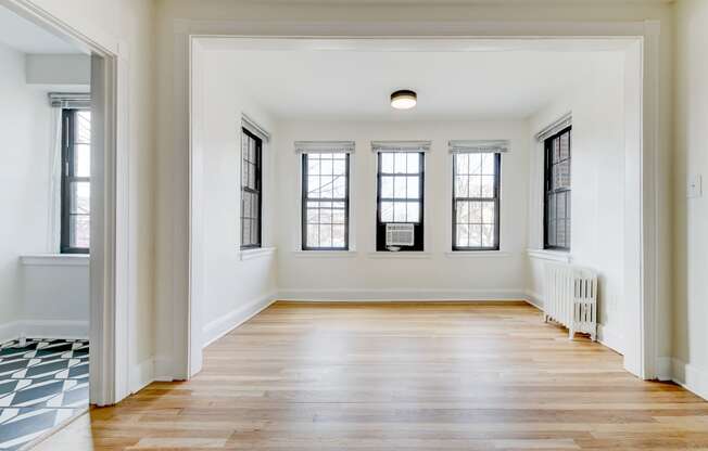 vacant living area with hard wood flooring and large windows at the dahlia apartments washington dc