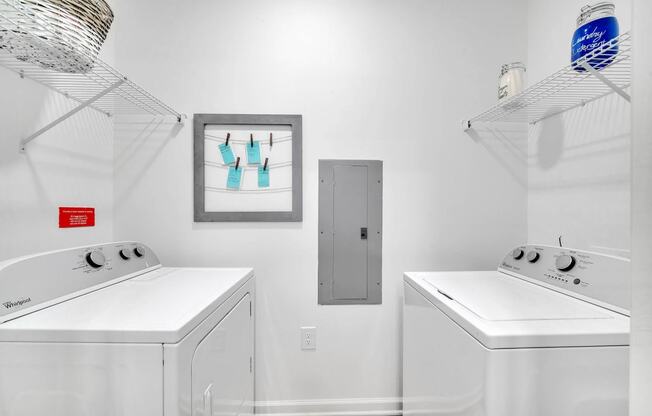 two washers and two dryers in a white laundry room with two white machines