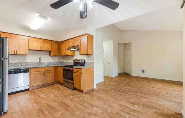 A kitchen with wooden cabinets and a black fan.